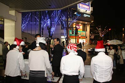 22日行われた三条昭栄地区イルミネーション事業点灯式で点灯したイルミネーションを前にハンドベル演奏