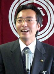 三条市旗を背に年頭のあいさつを行う国定