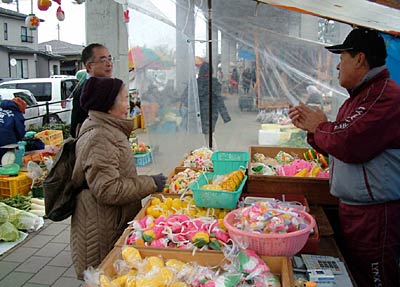12日の二七の定期市で繭玉飾りを売る露店
