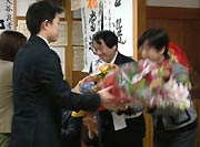 弥彦村職員から花束を受ける大谷氏
