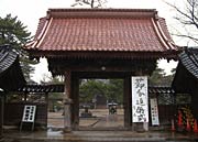 境内正面の門の前に立つ節分追儺式を知らせる看板