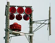 コンクリート柱の上に取り付けられたホーンスピーカーや無線アンテナ