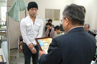 ミニチャンレジショップ「商売堂」の最後の卒業生に卒業証書を手渡す三条商工会議所の馬場副会頭