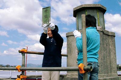 19日、常盤橋の橋名板の取りはずしで、「常盤橋」の橋名板をはずして掲げる5年生代表