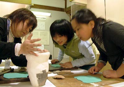 22日、三条市歴史民俗産業資料館で行われた「縄文体験の広場」で縄文土器の模様付けに挑戦する子どもたち