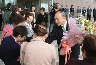 加茂市長選から一夜明けて登庁し、市役所玄関前で盛大な出迎えを受ける小池市長