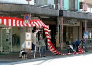 商店街で紅白幕を下げる商店主