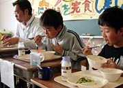 国定三条市長(いちばん左)も児童と一緒にドジョウのカレー揚げを味わう