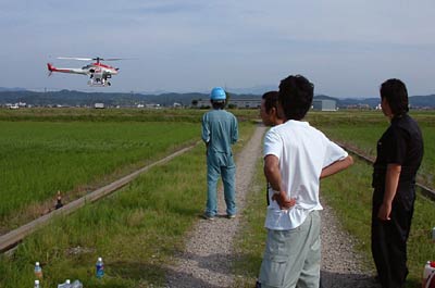 19日、三条市大宮新田で大型無人ヘリの操縦練習を行う南蒲原無人ヘリ協議会