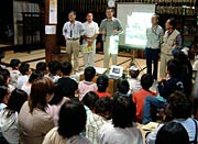 ビデオプロジェクターなどを使ってホタル観察の解説をする三条ホタルの会会員