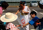 菓子をお年寄りに手渡す子どもたち