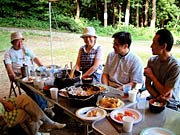 ダッチオーブンで調理したアウトドア料理を味わう参加者