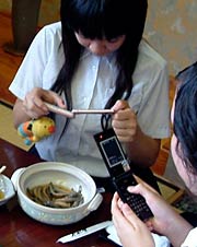 試食したドジョウ料理をケータイのカメラで撮影