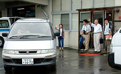 給食センター「味彩燕」でカレーライスを1,000食分を積んで柏崎市の避難所へ向かう車を見送る関係者ら