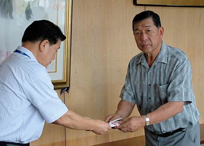 小林燕市長に吉田商工会会員から寄せられた善意60万円余りを手渡す泉谷会長