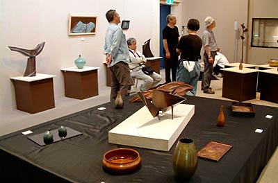 19日まで燕市産業史料館で開かれている水燕鎚工会作品展の初日前日に行われた展示作業
