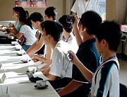 デジカメで様子を撮影する鄂州市教育代表団の中高校生