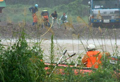 中州で進む作業をボートを待機して見守る消防職員(手前)
