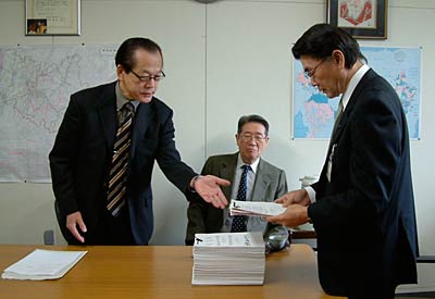 関崎経済部長に署名簿を手渡すパルム再生連絡協議会の箕輪会長(左)