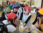 つきたてのもちを丸めるお母さんたち