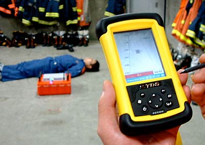 電磁波による探査装置、写真奥のオレンジの箱で探査し、心拍などを感知して手前のモニター画面に表示する