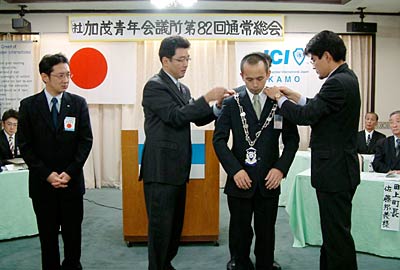 12日開かれた加茂青年会議所の82回12月通常総会で安田理事長から丸山次年度理事長へプレジデントリーフの伝達と理事長バッジの交換