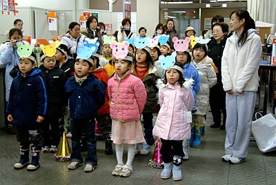 15日、年賀状初差出式が行われた三条郵便局でネズミの面をかぶって合唱する宝塔院幼稚園年長児
