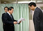 国定市長(右)に寄付の目録を贈る角利産業の加藤社長(右)
