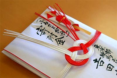 「ふるさと納税」と書き添えたNKSコーポレーションの100万円の寄付を包んだのし袋