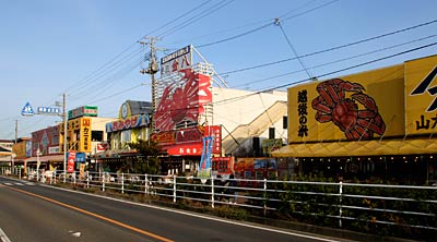 27日、抜けるような青空が広がって平日の割ににぎわう寺泊魚のアメ横