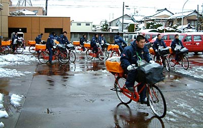 日本郵便三条支店で元旦出発式のあと自転車にまたがって年賀状配達に出発する高校生アルバイト