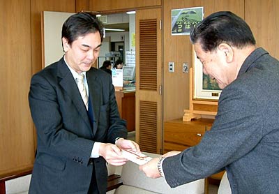  小林燕市長(右)に寄付を手渡すホクエツの浅野社長(左)