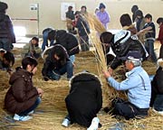 さいの神のに使うわらを巻く5、6年生