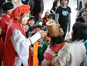 小づちで子どもの頭をなでる福の神