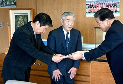 左から酒井さんの次男の実さん、弟の昭二郎さん、そして善意を受け取る小林燕市長