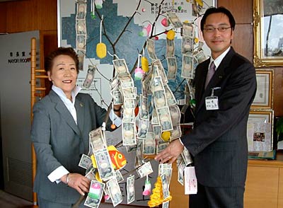 繭玉ごと20万円余りを寄付するスナックマンマの五十嵐さん(左)と国定市長(右)