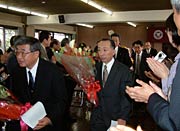 職員の拍手に送られて退場する退職者