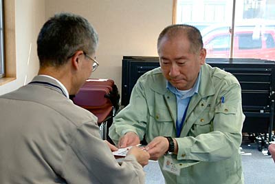 燕市社会福祉協議会吉田支所の大橋裕介支所長(左)に燕市合併2周年記念市民交流イベントの収益の一部35,500円を手渡す新市一体化市民交流イベント実行委員会の富所委員長