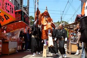 八幡宮を出発して参道を南進する大名行列の道祖神