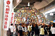 大通りのアーケートの下を進む万灯