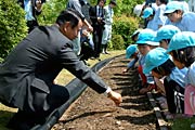 園児に種まきの手本を見せる島崎校長
