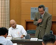 「観光モニュメントの移設を求める決議」の発議案を説明する阿部市議(右)とタナカ市議(左)