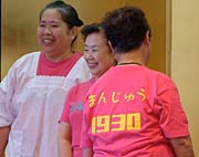 ショッキングピンクのTシャツの背中には職業と生年