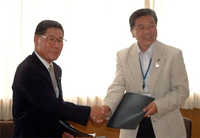 災害時の応援業務に関する協定を締結して握手する県測量設計業協会の古川会長(左)と小林燕市長(右)