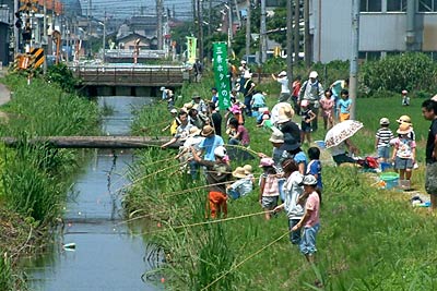 県立三条高校そばの新通川で開かれた三条ホタルの会の雑魚とり大会