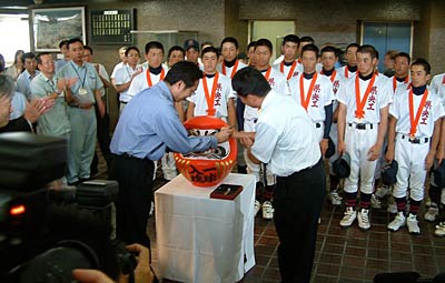 国定市長と鈴木監督でだるまの目入れ
