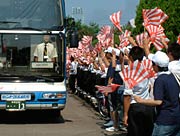 小旗を振って選手を見送る