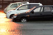 車のボディーの下で水が達した三条市上須頃地内の駐車場