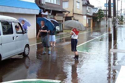 南新保、三条税務署付近で雨の状況を見守る市民