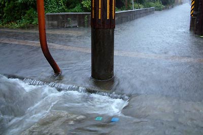 横町2付近で川のように道路を流れる雨水